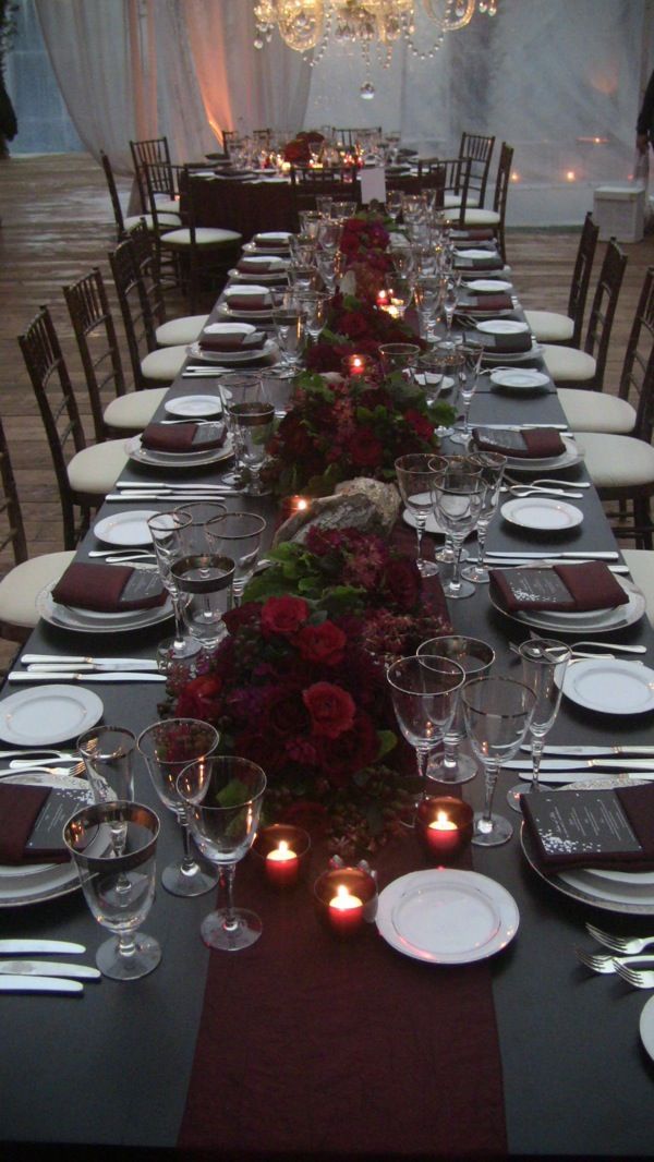 a long table set with place settings and candles