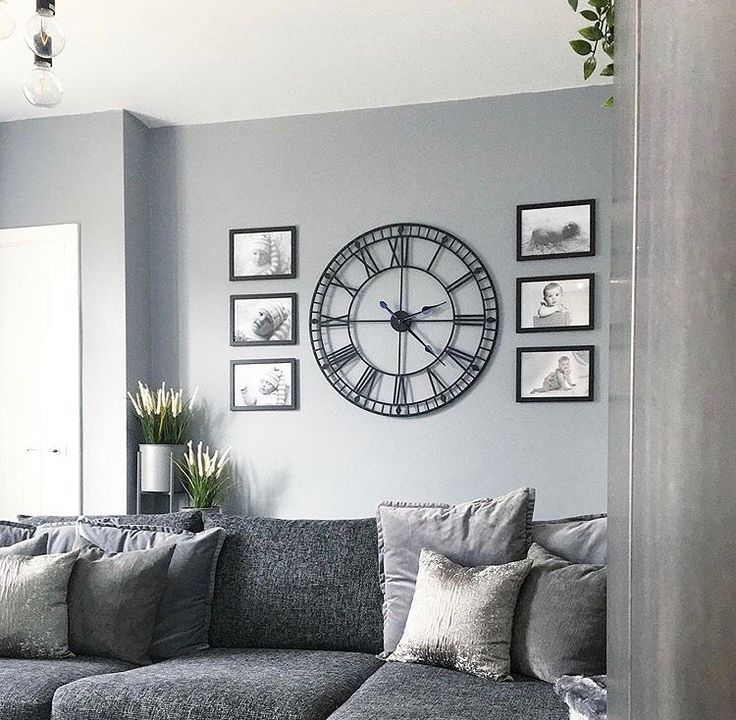 a living room filled with furniture and a large clock on the wall