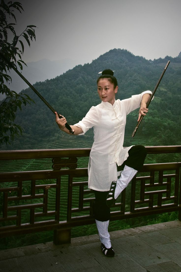 a woman holding two poles on top of a balcony