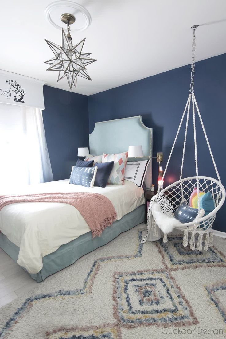 a bed room with a neatly made bed and a hanging chair