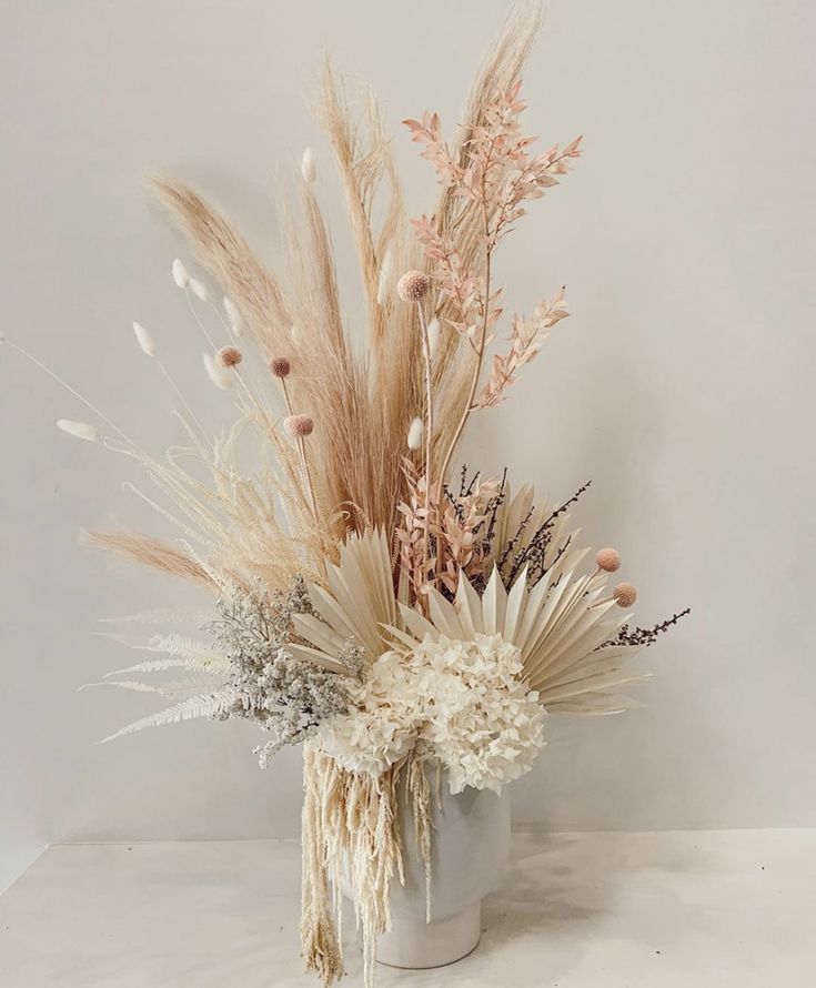 an arrangement of dried flowers in a vase