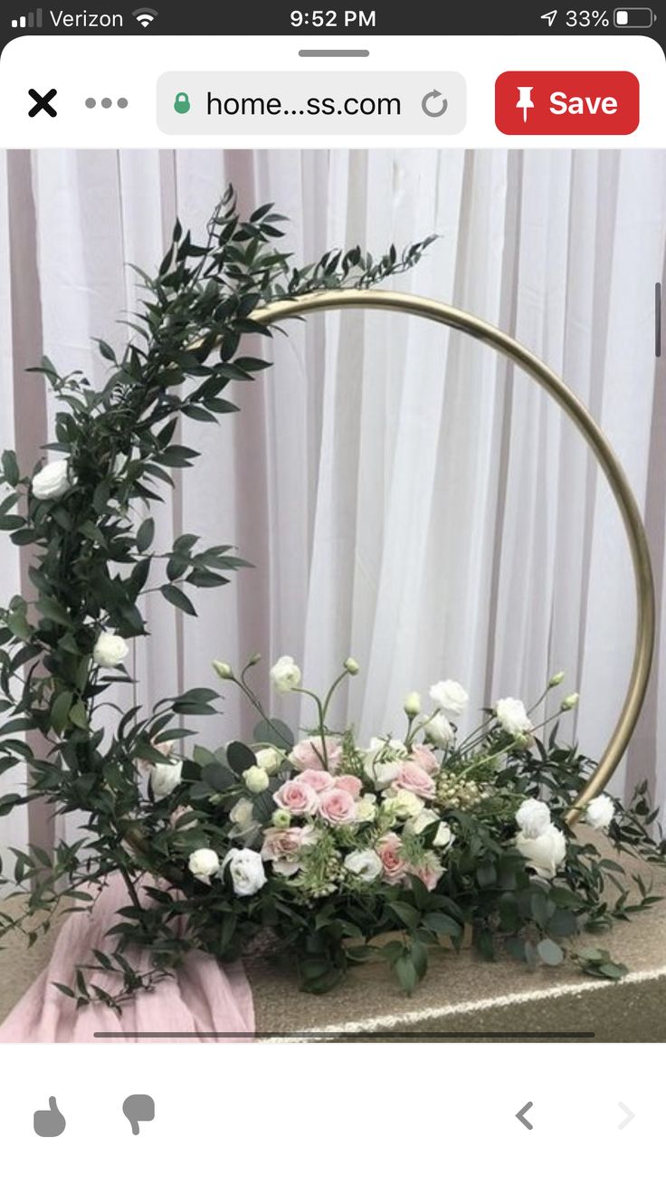 a flower arrangement on top of a gold box with pink and white flowers in it