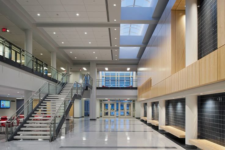 an empty building with stairs and tables in the center, leading up to two floors