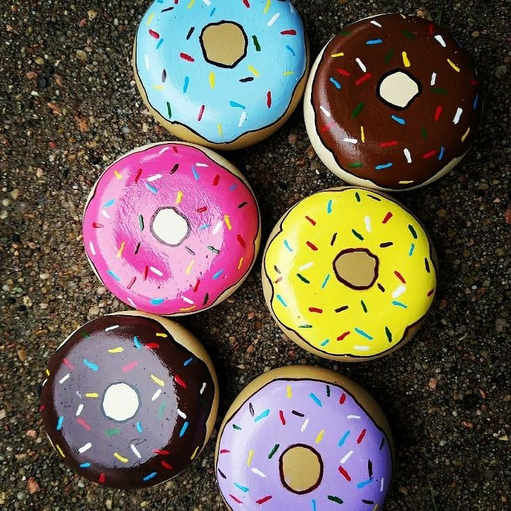 four donuts with different colored sprinkles on them sitting in a circle