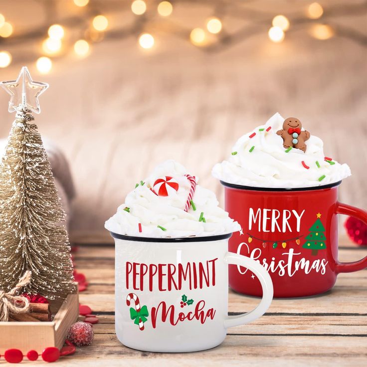 three coffee mugs with christmas decorations on the table next to a small christmas tree