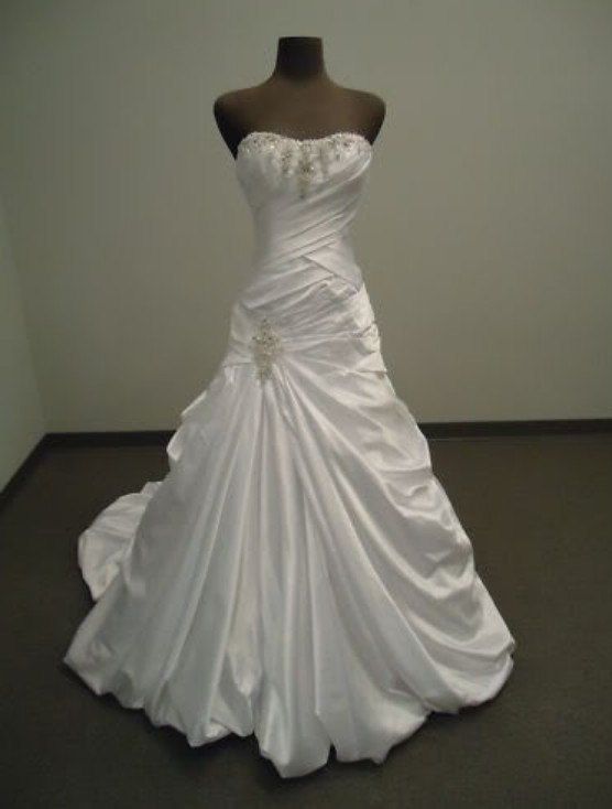 a white wedding dress on display in a room