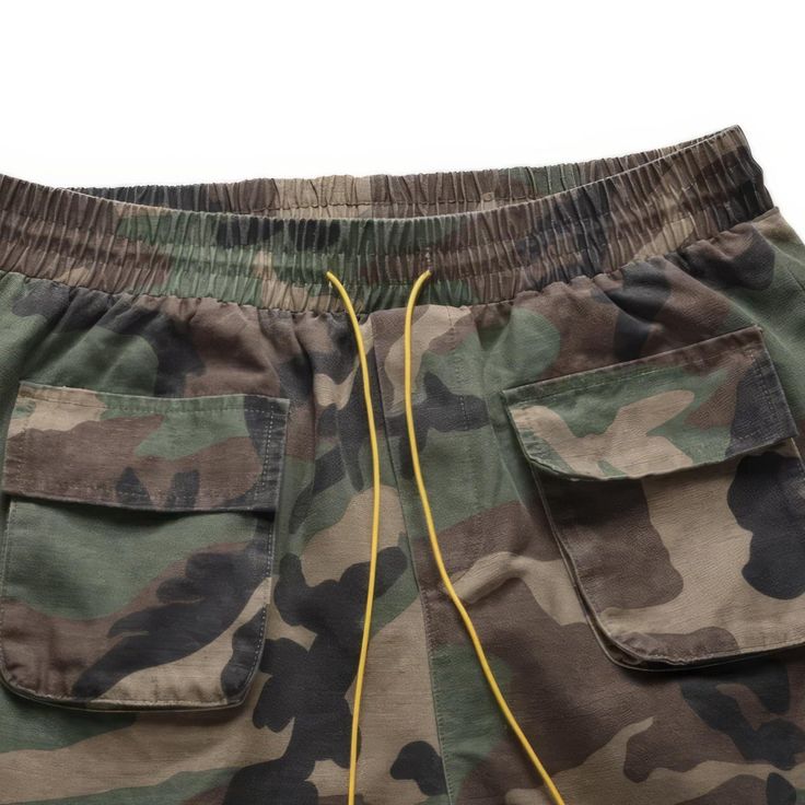 These multifunctional cargo shorts camouflage are designed for maximum comfort and freedom of movement. Its ample fit offers superior breathability. The high street pattern and urban streetwear look make for a one-of-a-kind piece that will surely elevate your fashion sense. Stand out and express your individual style with this cargo short that boasts multiple pockets. Cotton Fabric Distressed Yellow drawstring closure Camouflage patten Elastic waist, drawcord, loose fit for comfort. Made from br Khaki Shorts For Streetwear, Urban Style Cargo Shorts For Outdoor, Khaki Military Shorts For Outdoor Activities, Khaki Techwear Shorts For Streetwear, Military Style Khaki Shorts For Outdoor Activities, Khaki Shorts With Side Pockets For Streetwear, Urban Cargo Style Shorts For Streetwear, Sporty Camouflage Bottoms With Pockets, Khaki Cargo Pocket Shorts For Streetwear