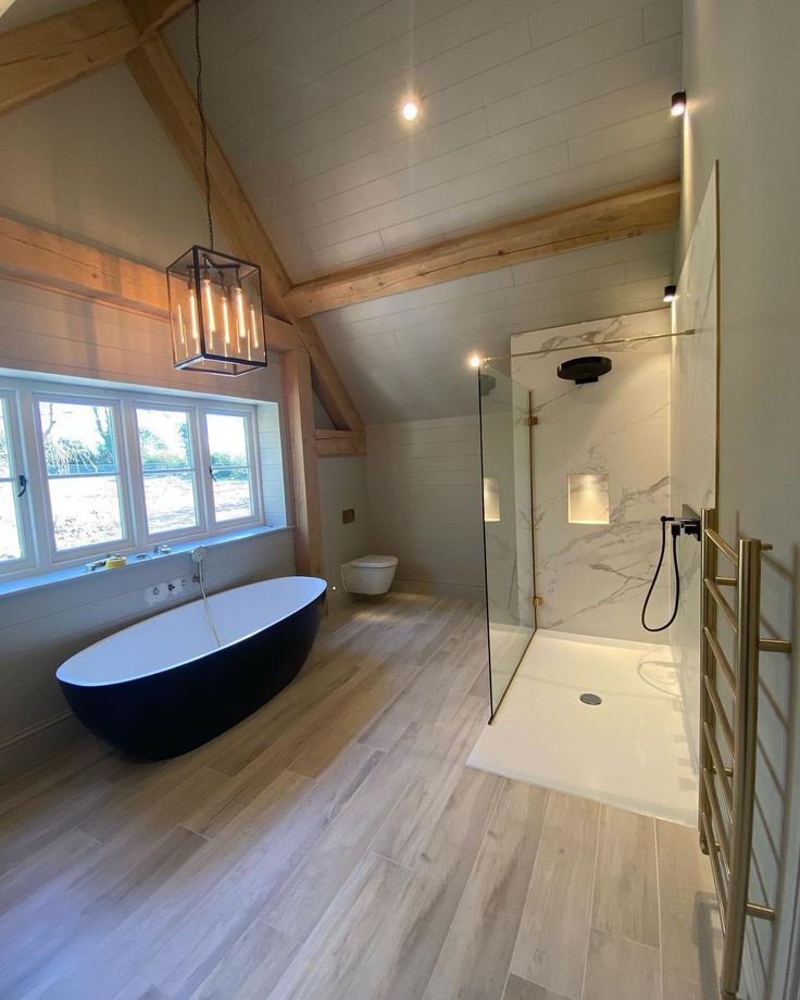 a bathroom with a large tub and wooden floors