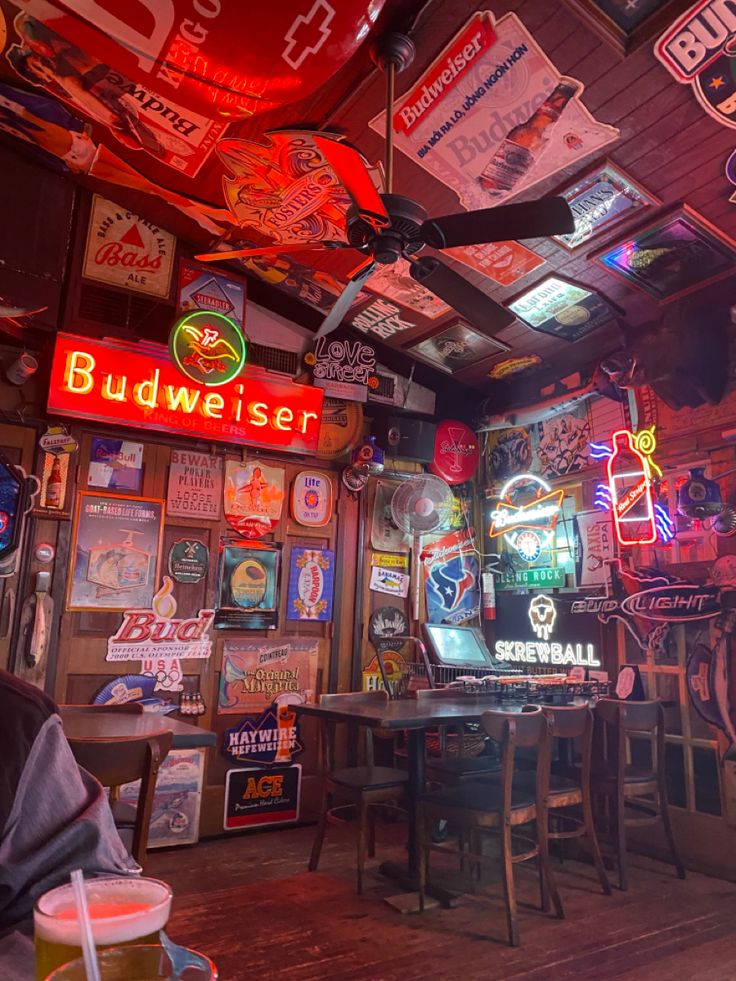 a man sitting at a table in a bar with neon signs on the walls and ceiling