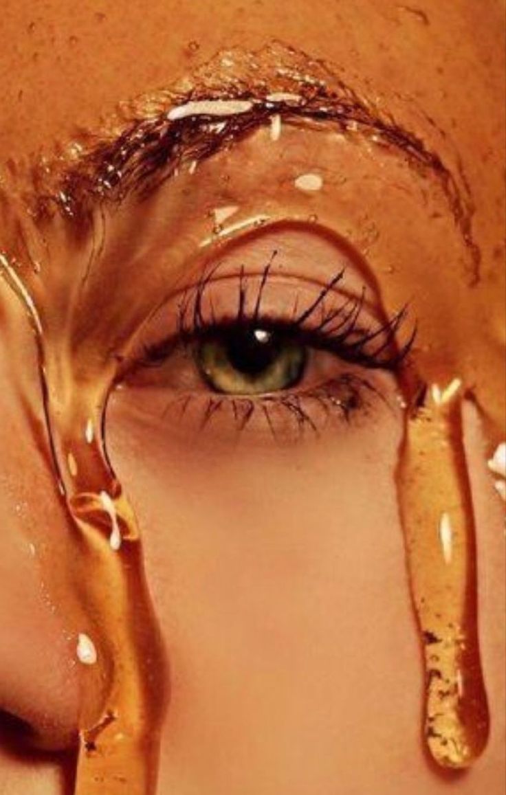 a woman's face with brown liquid dripping from her eyes and eyeliners