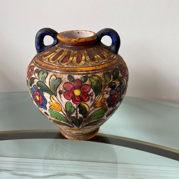 an ornate vase sitting on top of a glass table