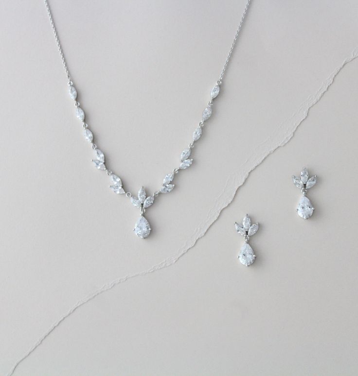 a necklace and earring set on a white surface