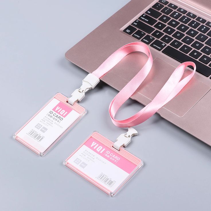 two pink lanyards are attached to a laptop