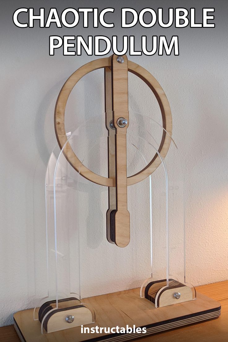 a wooden pendulum on top of a table next to a wall mounted clock with the words, chaotic double pendulum