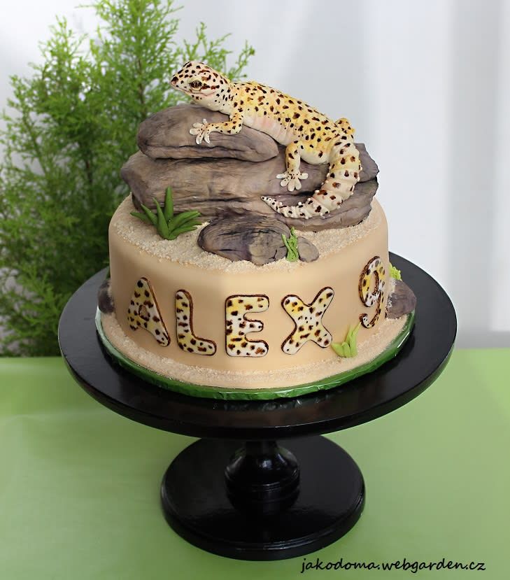 a cake decorated with leopards is sitting on a black plate and green tablecloth