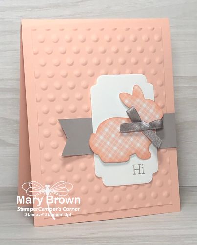 a close up of a card with a bow on the front and an embellishment in the middle