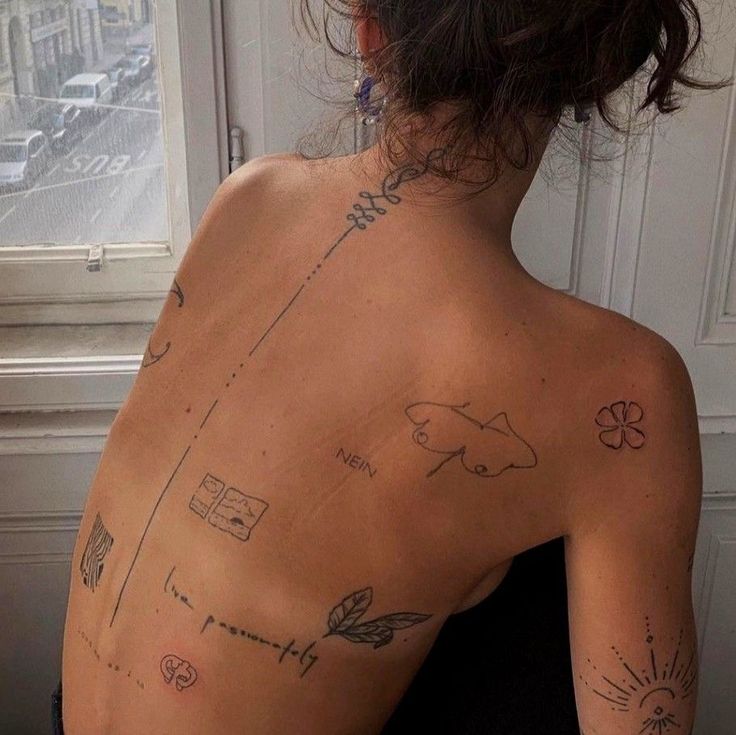 the back of a woman's body with tattoos on it