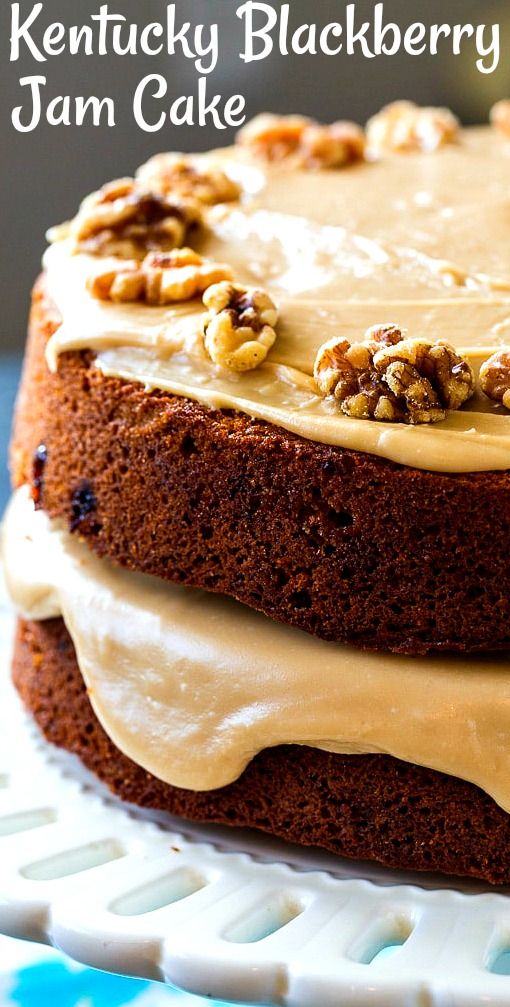 a close up of a cake with frosting and walnuts on top, sitting on a plate