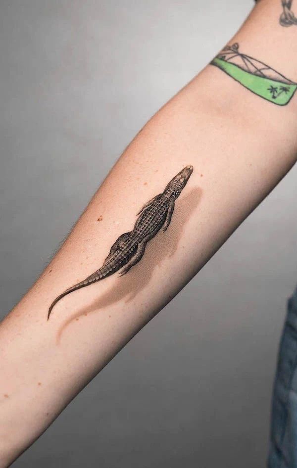 a lizard tattoo on the arm