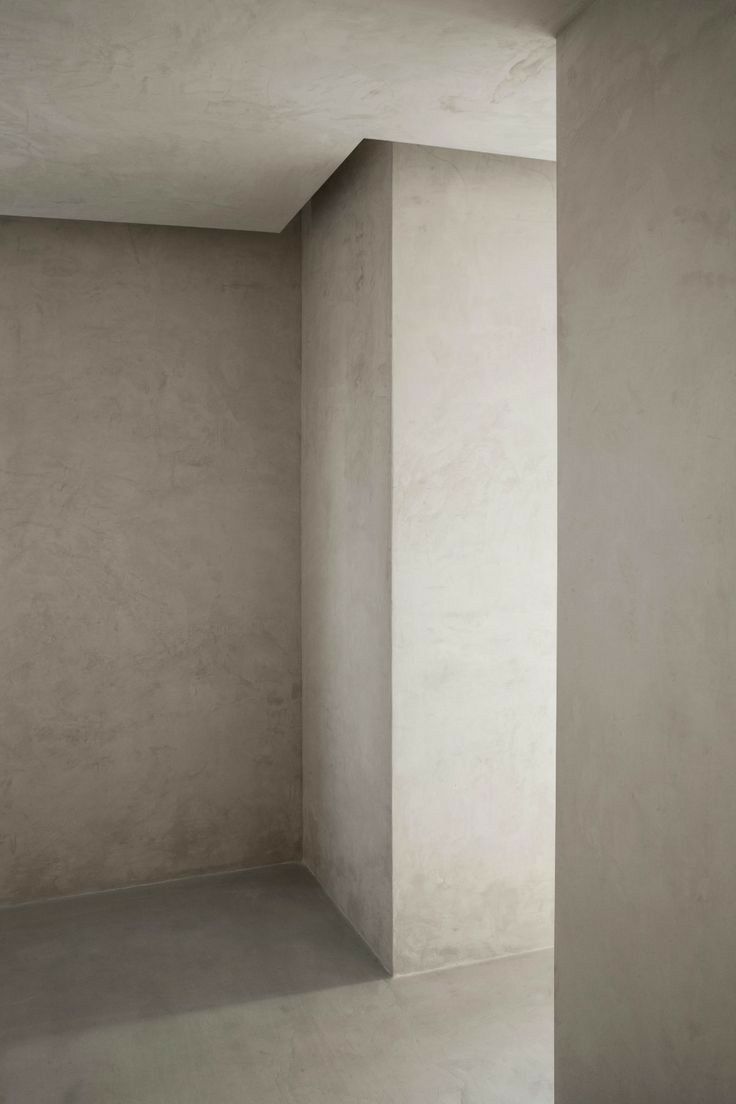 an empty room with concrete walls and floor