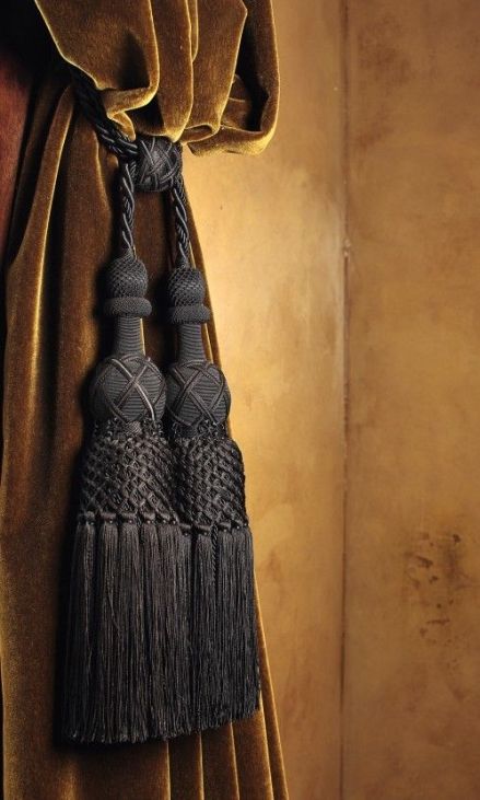 a curtain with two tassels hanging from it's side in front of a wall