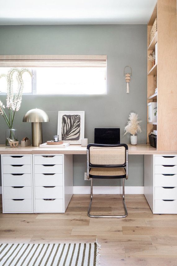 a chair sitting on top of a wooden floor in front of a desk with drawers