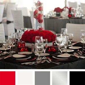 the table is set with red roses, silverware and white place settings for dinner