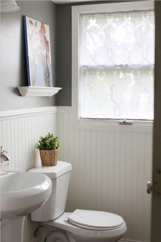 a white toilet sitting next to a window in a bathroom