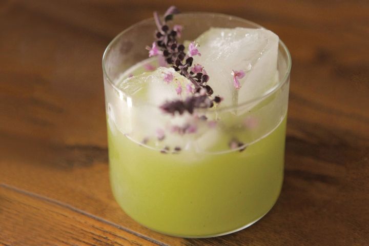 a glass filled with ice and flowers on top of a wooden table