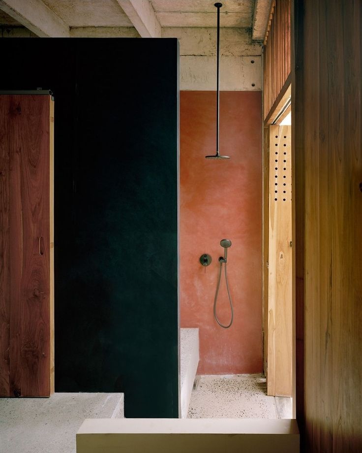 an open door leading to a bathroom with pink walls and black trim on the walls