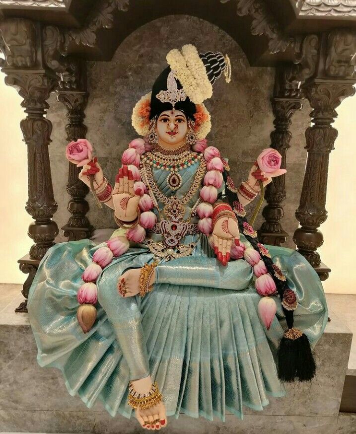 a statue of a woman sitting on top of a stone bench with flowers in her hand