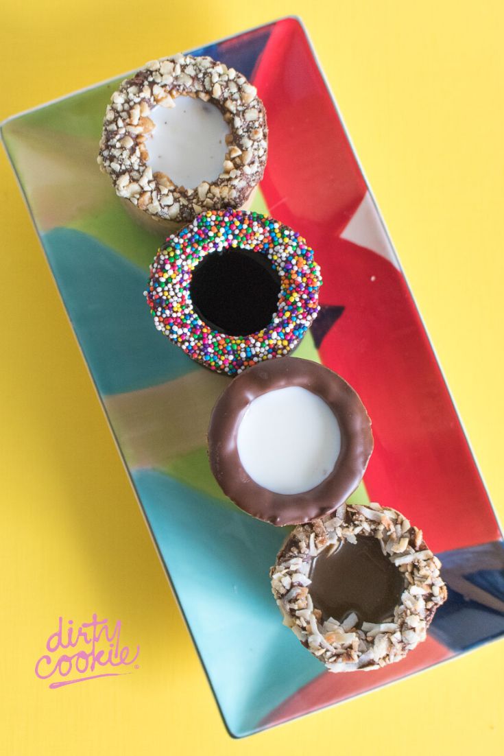 three donuts with sprinkles and chocolate on a colorful plate against a yellow background