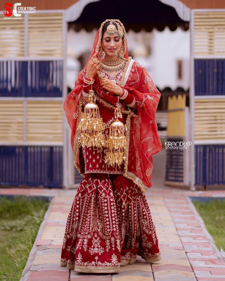 a woman in a red and gold bridal outfit