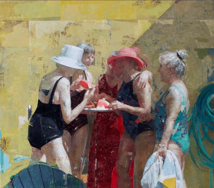 three women in bathing suits are eating watermelon from a plate on a table