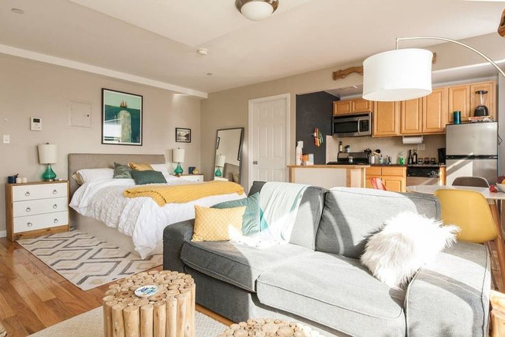 a living room filled with furniture next to a kitchen and dining room table in front of a bed