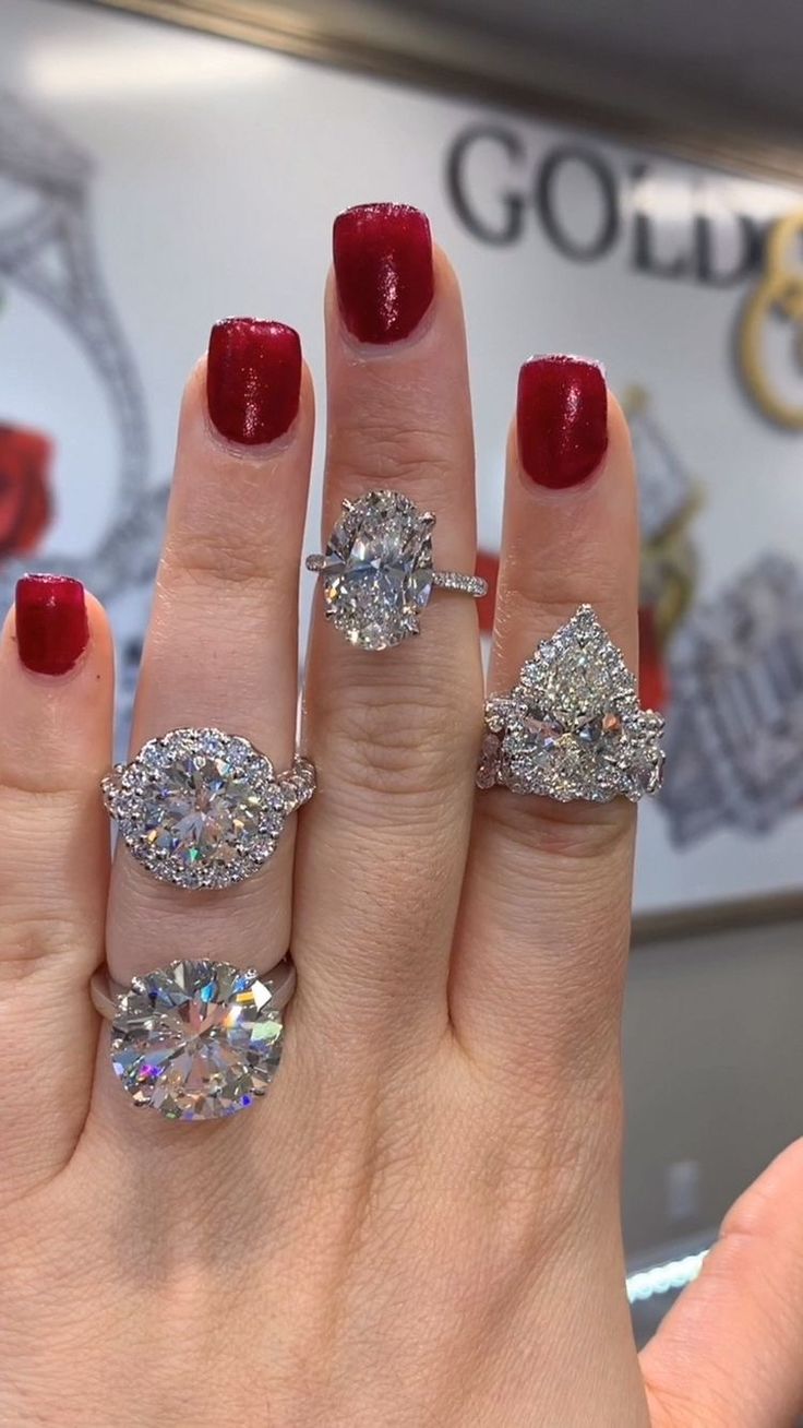 a woman's hand with three different rings on her fingers and two diamond engagement rings