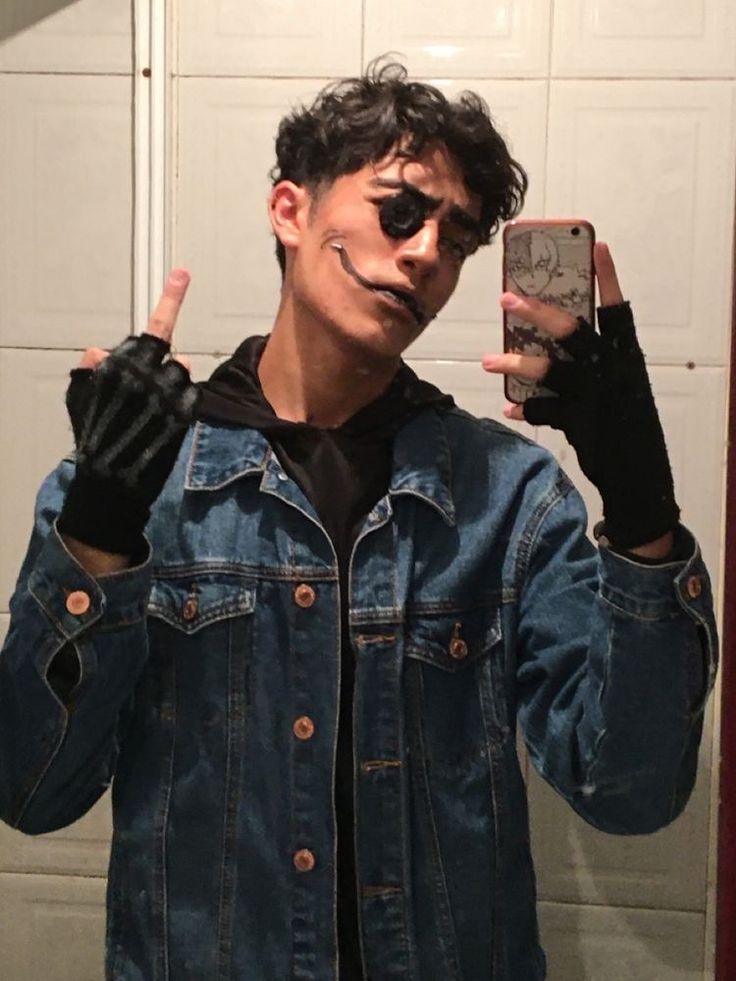 a young man wearing black gloves taking a selfie in the mirror