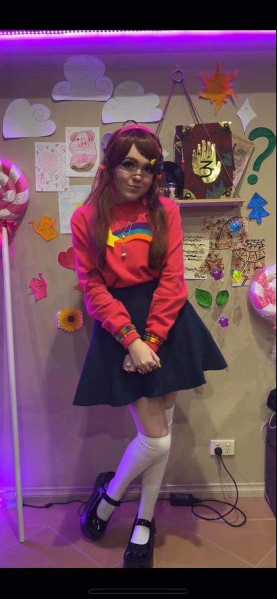 a woman standing in front of a wall covered with magnets and paper hearts on it