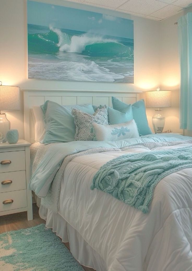 a white bed sitting under a painting on the wall next to a night stand with two lamps