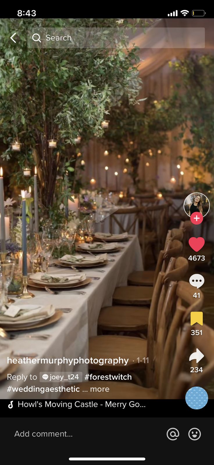 an image of a table setting with candles and flowers in the center, surrounded by greenery