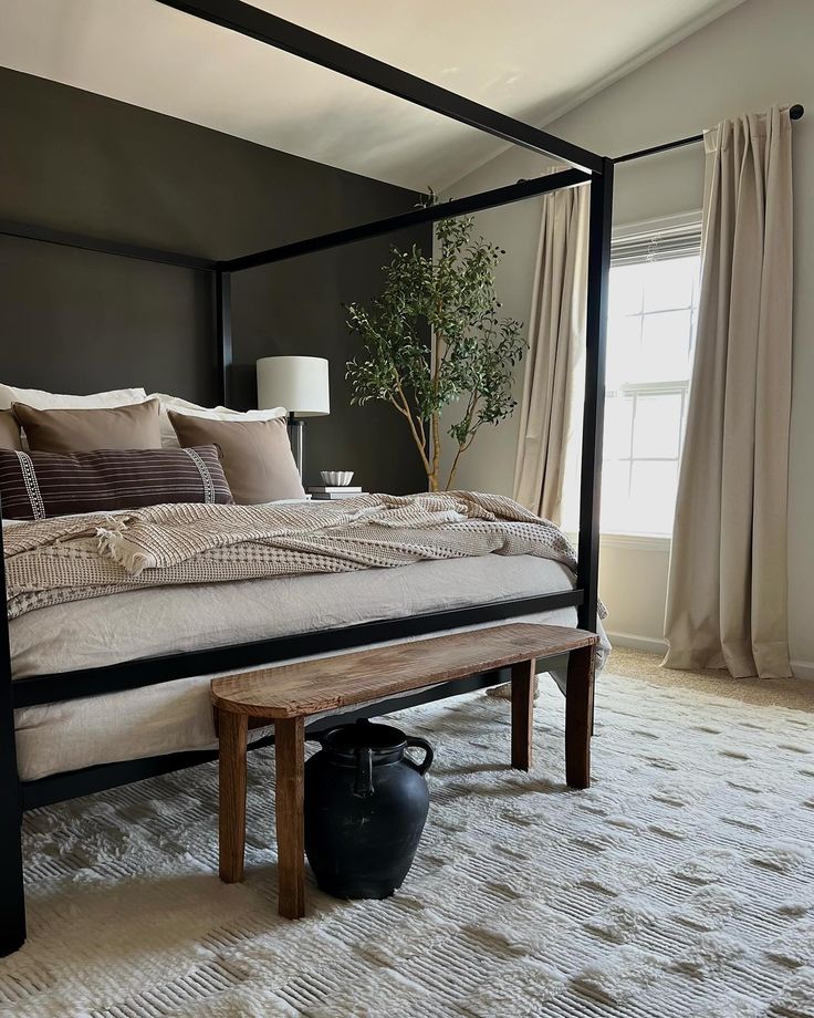 a bedroom with a four poster bed and white rugs on the floor next to a window