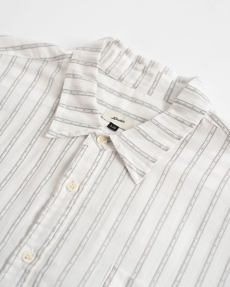 Much like our Leisure Pants, we’ve coined this our bleasure shirt: half-business, half-pleasure. Utilizing a lightweight, 100% cotton fabric from Japan, this fine stripe is sure to be a staple in your warm weather wardrobe this High Summer 100% Organic Cotton Dobby fabric 100 GSM Split hem Classic collar Front chest pocket Slightly oversized fit - size down if you want a more fitted look Fabric sourced from Japan Made in Canada Classic Summer Shirt With Horizontal Stripes, Striped Relaxed Fit Shirt For Business Casual, White Shirt With Horizontal Stripes In Relaxed Fit, Striped Everyday Summer Shirt, Summer Pinstripe Cotton Shirt, White All Over Print Beach Camp Shirt, White Tropical Cotton Camp Shirt, White Horizontal Stripe Relaxed Fit Shirt, White Unstructured Cotton Camp Shirt