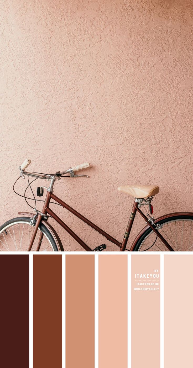 a bike parked against a pink wall in front of a light brown color swatch