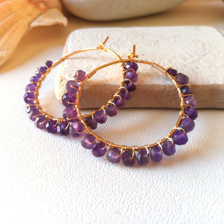 These hoop earrings are handcrafted in Italy with 14k gold plated wire and amethyst stones. They are elegant and versatile earrings, perfect for any occasion. Amethyst is a stone that symbolizes serenity and spirituality, and is an ideal gift for a special person. Earrings Features: Diameter: 3.3cm Stones: amethyst approximately 4 mm Structure: resistant but not rigid Closure: hook The photos are taken up close to illustrate details and give the impression of being larger. Please check the actua Nickel-free Purple Hoop Earrings, Purple Amethyst Hoop Jewelry, 14k Gold Filled Gemstone Hoop Earrings, Handmade Purple Hoop Earrings, Amethyst Hoop Earrings Gift, Gift Amethyst Hoop Earrings With Ear Wire, Handmade Small Purple Hoop Earrings, Purple Handmade Small Hoop Earrings, Amethyst Hoop Earrings With Ear Wire, Gift