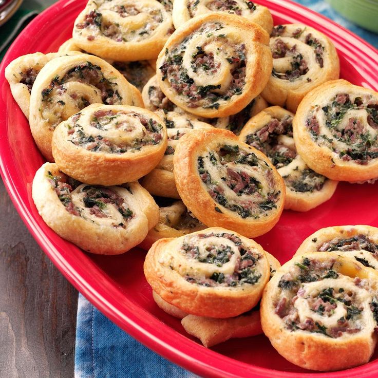 a red plate filled with mini pizzas on top of a table