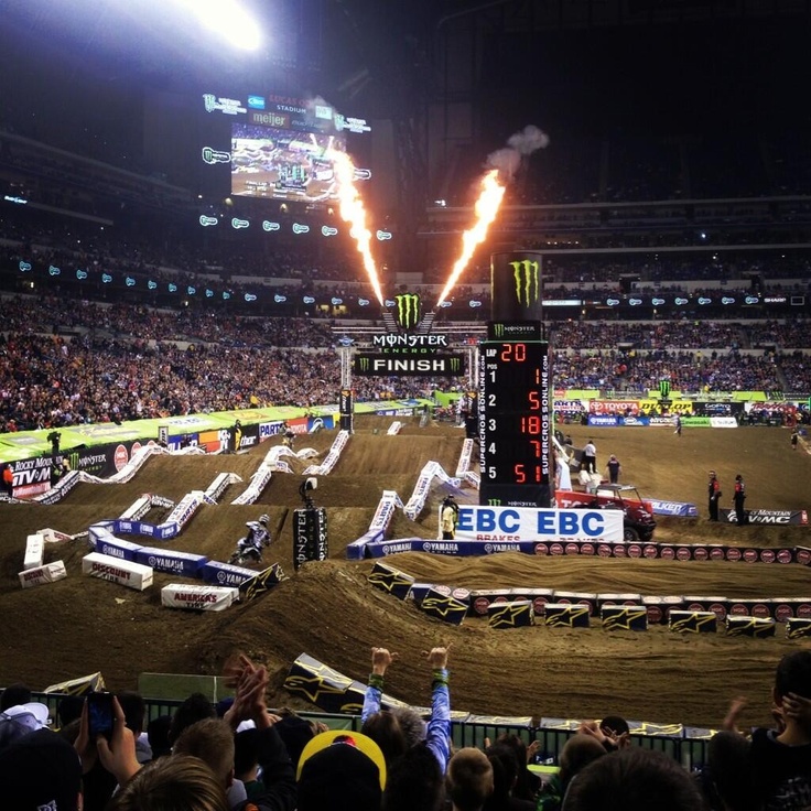 a group of motorcyclists riding on top of dirt bikes in front of a crowd