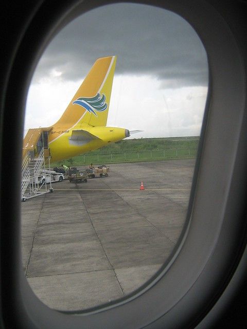 an airplane is parked on the tarmac with another plane in the background as seen from inside