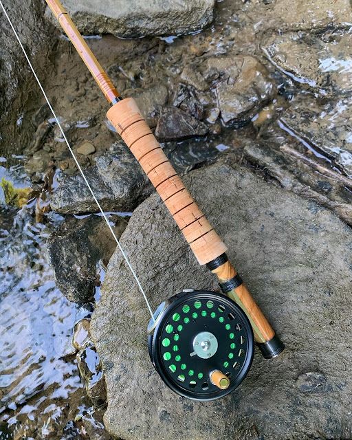 a fishing rod and reel sitting on some rocks