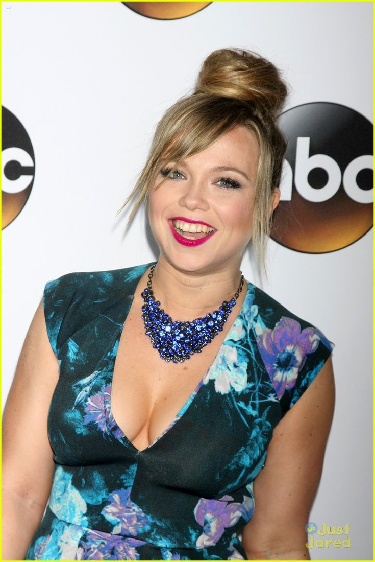 a woman in a floral dress smiling for the camera