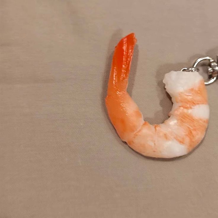 an orange shrimp keychain hanging from a chain